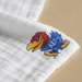 Close-up texture detail of University of Kansas Jayhawks muslin swaddle blanket showing premium cotton weave, softness, crimson and blue pattern with KU logo, and breathable quality