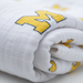 Close-up detail of University of Michigan Wolverines four-layer muslin toddler blanket showing premium organic cotton texture, layers, and quality construction in maize and blue