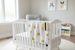 niversity of Michigan Wolverines four-layer muslin toddler blanket draped over white crib in nursery, showing maize and blue colors and official U of M logo, premium organic cotton