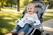 Toddler in stroller covered with Michigan State University four layer muslin blanket - green and white Spartans baby blanket for on-the-go comfort