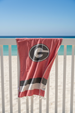 UGA beach towel blowing in wind on fence
