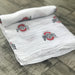 Ohio State Buckeyes muslin swaddle blanket fully displayed showing 47x47 size, officially licensed OSU baby blanket for newborns
